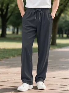 Detailed view of men's dark grey corduroy trousers featuring elastic drawstring waist