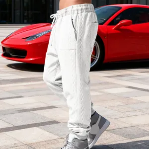 Detail view of men's white heavy jacquard sweatpants with cable-knit texture.