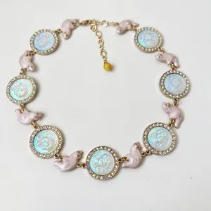 Detailed view of iridescent relief cameo necklace with resin kittens and rhinestones
