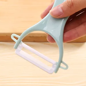 Keramische groenteschiller in Y-vorm met ergonomisch lichtblauw handvat en mesje