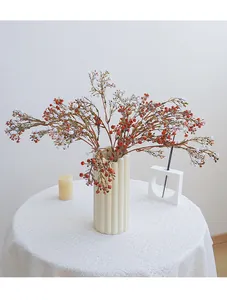 Künstlicher Wachsblumen-Zweig in Keramikvase für Tischdekoration und schöne Heimfloristik.