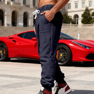Detail view of men's navy blue heavy jacquard joggers with a relaxed fit and drawstring waist.