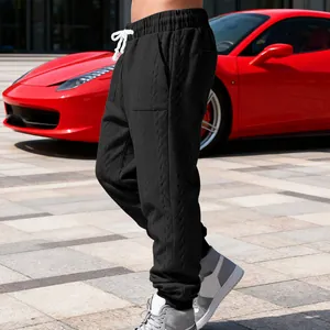 Macro view of men's premium black heavy jacquard sweatpants featuring white drawstring details.