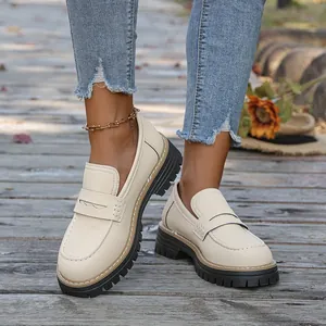 Elegant cream platform loafers with chunky black lug soles and retro British style.