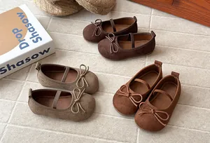 Detailed view of matte girls' Mary Jane shoes with butterfly bows in earth tones