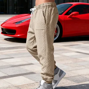Close-up of heavy jacquard cable-knit texture on khaki men's joggers.