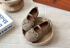 Detailed macro view of girls' brown frosted suede shoes with a delicate bow knot