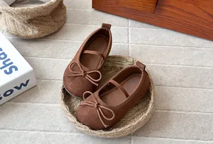 Detailed macro view of brown suede girls' bow princess shoes featuring comfortable soft soles