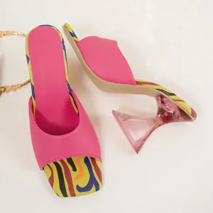 Elegant pink square toe mules featuring vibrant patterned soles and clear block heels