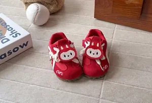 Detail view of red children's sports shoes featuring a cute cartoon rabbit emblem