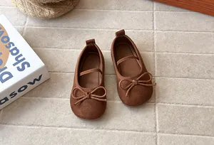 Top down view of brown suede girls' Mary Jane flats featuring a decorative bow detail