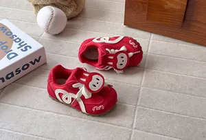 Close-up of red kids sneakers featuring a cute cartoon animal face and soft sole.
