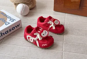 Detailed view of red children's sneakers featuring a cute cartoon rabbit patch design
