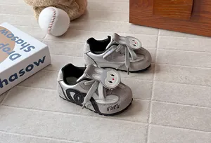 Detail view of grey children's sneakers with cute cartoon rabbit patch and soft soles.