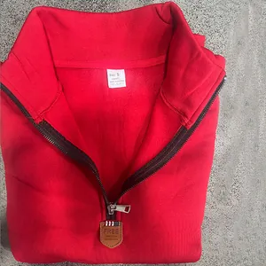 Close-up detail of a red heavy fleece sweatshirt with stand-up collar and silver half-zip
