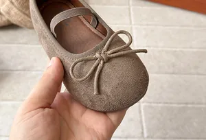 Close-up of brown suede girl's Mary Jane shoe featuring a delicate bow detail.