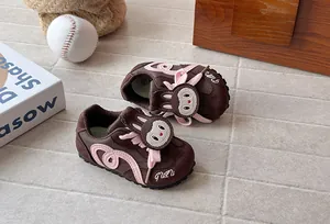 Close-up of brown and pink children's cartoon sneakers with soft soles