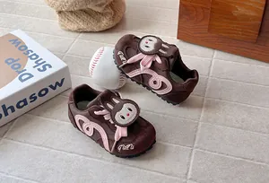 Close-up of children's brown suede sneakers with cute pink rabbit cartoon design