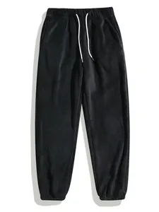Detailweergave van een zwarte fleece joggingbroek met witte koorden en elastiek.