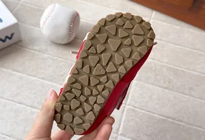 Close-up of the non-slip rubber outsole on a red toddler sneaker with size 24.