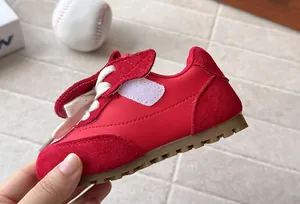 Close-up of red children's casual trainer with suede finish and gum sole