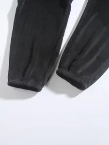 Detailopname van de textuur en de elastische manchet van een zwarte fleece sportbroek