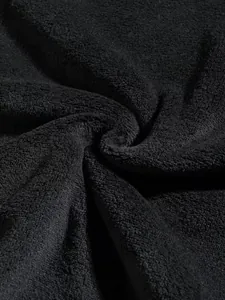 Inquadratura dettagliata della trama del tessuto in pile nero per felpe o pantaloni sportivi.