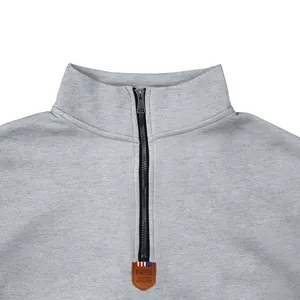 Close-up of grey heavyweight fleece sweatshirt featuring 1/4 zipper detail and leather patch