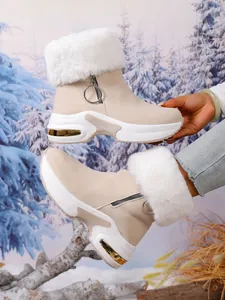 Detailed side view of beige suede snow boots with white faux fur and platform sole