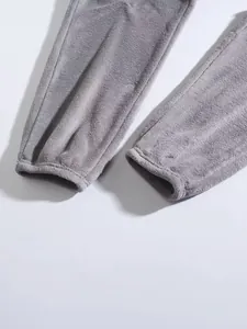 Detailopname van een grijze pluche fleece joggingbroek met zachte textuur en boorden