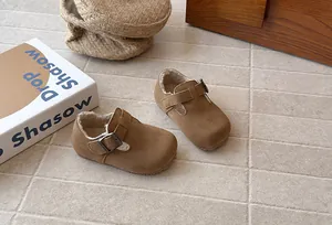 Detail view of retro brown suede children's shoes with warm fleece lining and buckle strap