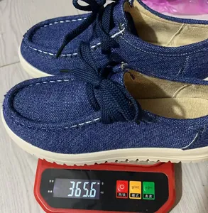 Detailopname van het gewicht van een blauwe denim bootschoen op een digitale weegschaal.