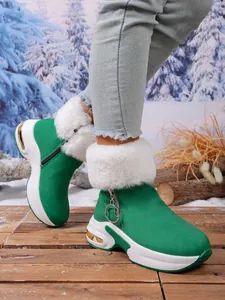 Detailed view of stylish green women snow boots with white faux fur trim and platform sole