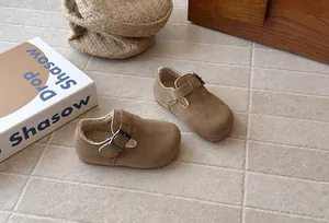 Detail of retro brown suede children's shoes with warm fleece lining and buckle.
