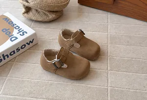 Detail of brown faux suede toddler shoes with warm plush lining and buckle closure