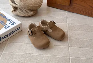 Close-up of brown suede children's warm shoes with cozy fleece lining and buckle strap
