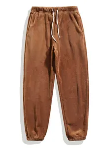 Detail van de bruine heren fleece joggingbroek met een wit trekkoord in de tailleband.