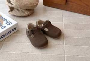 Close-up of retro toddler fleece shoes with cozy white lining and buckled strap