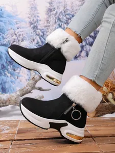 Detail view of women's black snow boots with white faux fur trim and platform sole.
