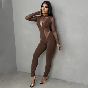Vista detallada de un sexy mono marrón ajustado con inserciones de malla y cuello alto