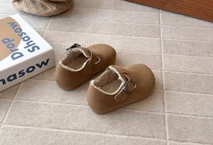 Detailed view of retro brown children's fleece-lined shoes with adjustable buckle strap