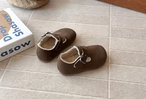 Detailed view of children's vintage brown suede shoes with warm white fleece lining.