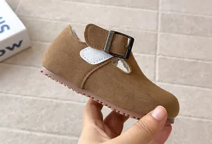 Close-up of vintage brown suede T-strap kids' shoe with soft non-slip sole