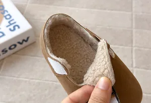 Close-up detail of the warm plush lining and velcro strap on children's winter shoes