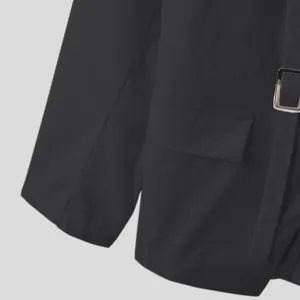 Dettaglio di un blazer nero slim fit da uomo con fibbia in metallo e tasca a patta
