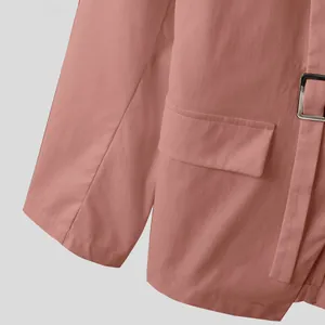 Primo piano dettagliato della chiusura con fibbia e tasca di un blazer rosa da uomo