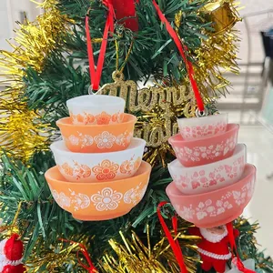 Primo piano di ornamenti in acrilico a forma di ciotole impilate su un albero di Natale.