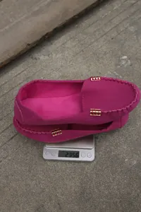 Detalle de mocasines rosas en una báscula que muestra un peso de 235,60 gramos