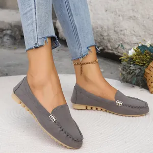 Detalle de mocasines elegantes de mezclilla gris con hebilla de metal en alfombra