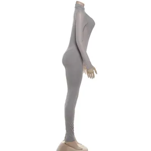 Vista lateral de un mono sexy gris de manga larga con parches de malla para mujer